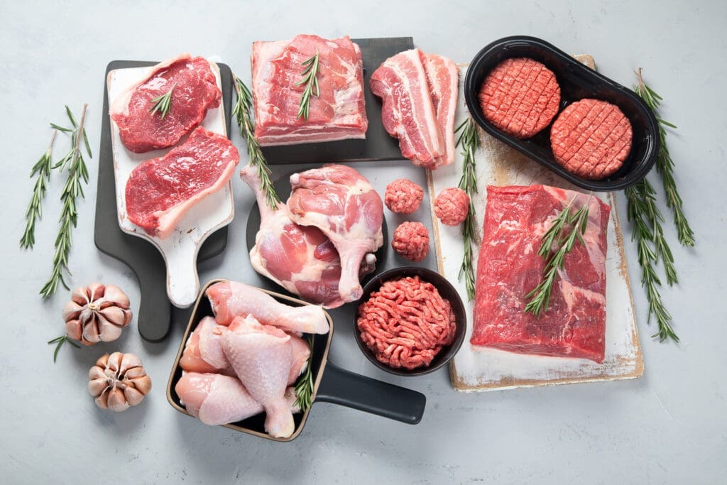 Assortment of raw meats on grey background. Top view, flat lay